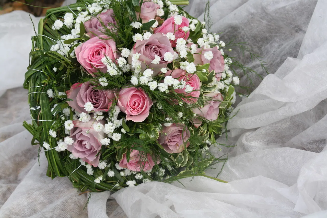 Runder Strauß aus rosa und altrosa Rosen mit Schleierkraut
